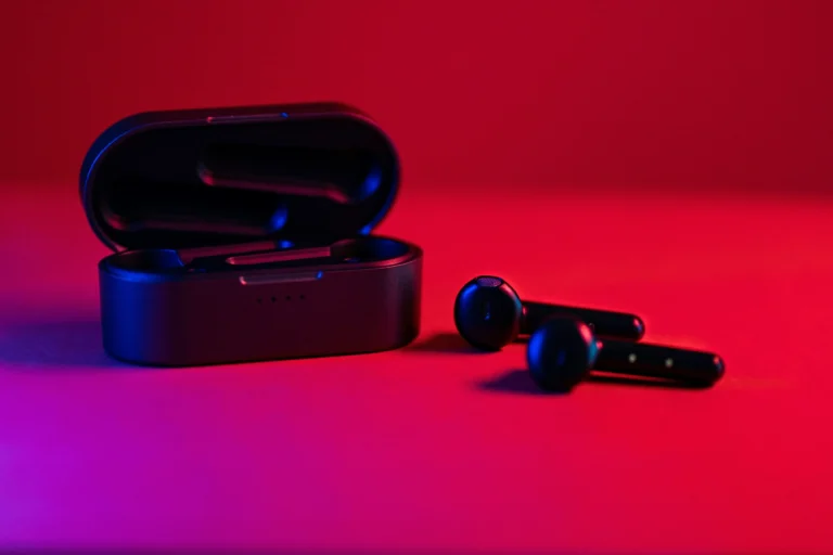 a close up of an earbud with a neon lit background