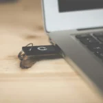 the car key is by the laptop on the table