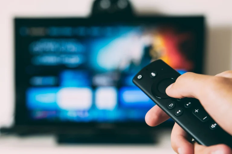 a close up of a person holding a remote control