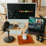 a computer with two monitors on and a laptop with headphones