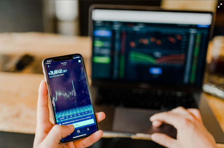 someone on their cell phone displaying financial data and statistics