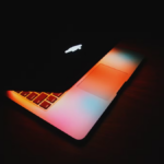 a colorful laptop in a dark room